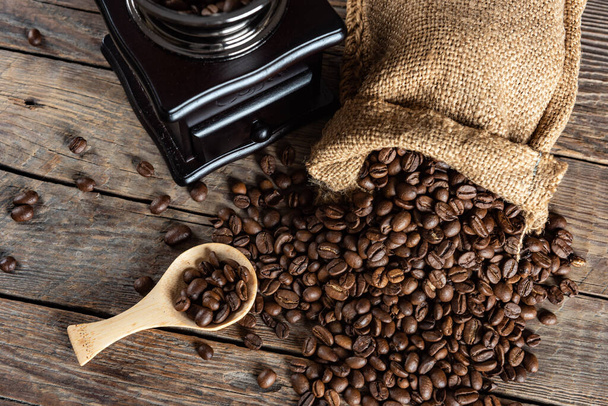 Coffee beans and retro manual coffee grinder on wooden table - Φωτογραφία, εικόνα