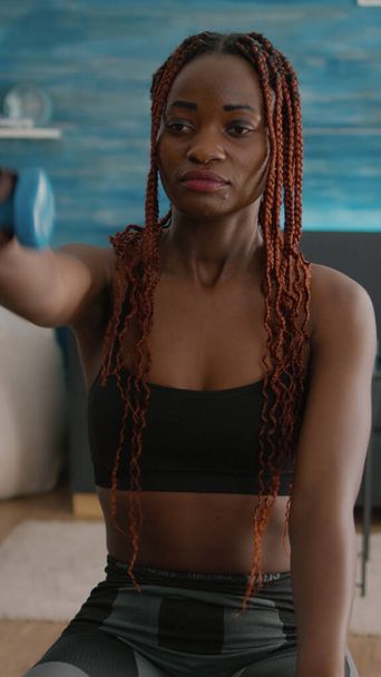 Donna nera atletica che esercita esercizi corporei con manubri yoga - Foto, immagini