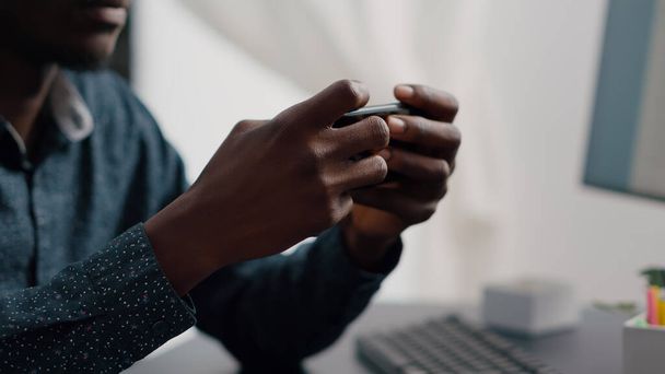 Close up of black man hands playing online internet mobile video games - Zdjęcie, obraz