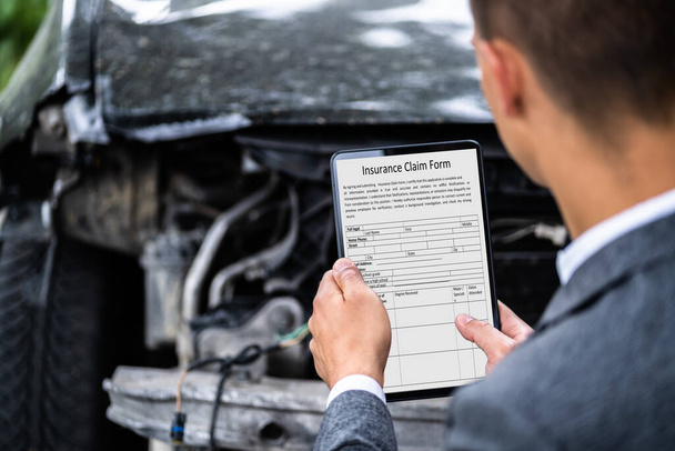 Insurance Agent Inspecting Damaged Car With Digital Tablet - 写真・画像