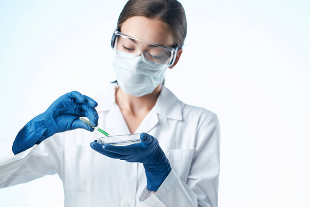 laboratory assistant in a white coat medical mask research analyzes - Φωτογραφία, εικόνα