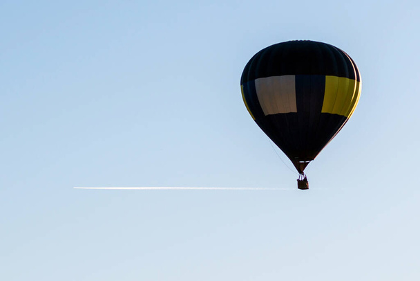 青い空に熱気球が飛んできます。青い澄んだ空に青い黄色い熱気球が一つ。. - 写真・画像