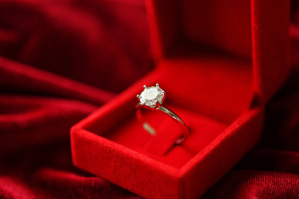 Diamant ring in sieraden geschenkdoos op rode stof achtergrond - Foto, afbeelding