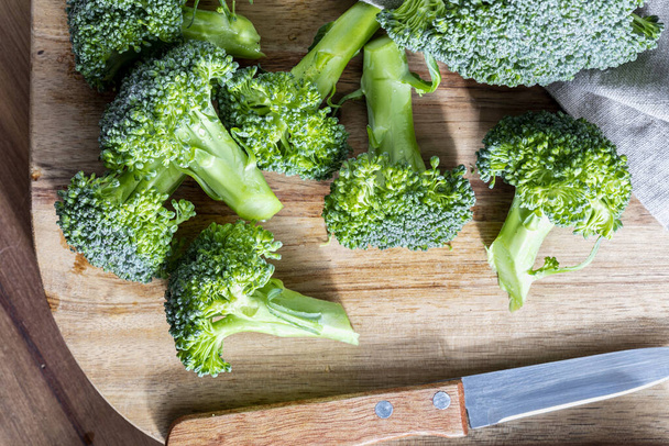 Close-up of raw, fresh broccoli (broccoli brote, brassica oleracea) stalks with drops of water in the preparation process. Mediterranean diet food. Top view. - Photo, Image