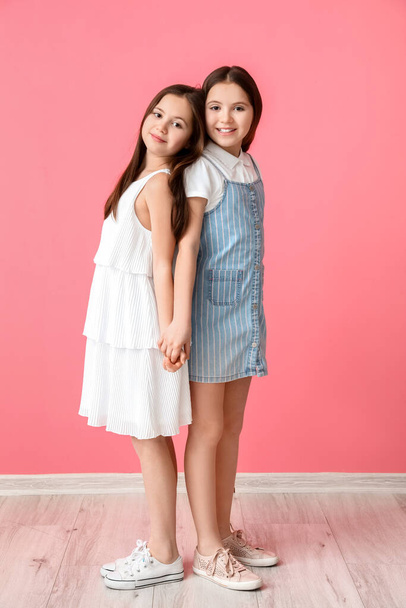Cute twin girls on color background - 写真・画像