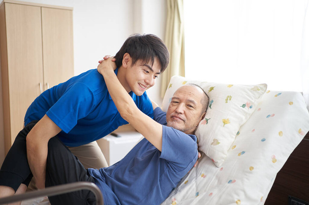 Männlicher Pfleger mit einem älteren Menschen - Foto, Bild