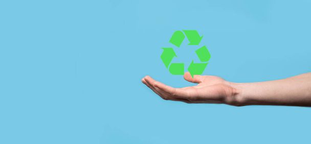 手はリサイクルのアイコンを保持します。生態系と再生可能エネルギーの概念。地球の日のシンボル、自然保護の概念. - 写真・画像