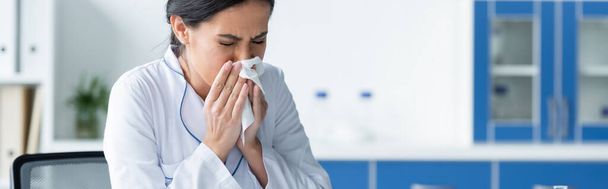 Doctor in white coat sneezing in clinic, banner  - Photo, Image