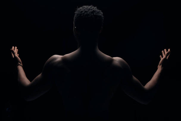 photograph of a dark-skinned young guy with an illuminated portrait. Photo with outstretched arms - Foto, Bild