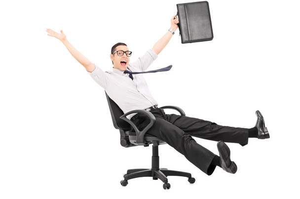 Businessman riding in office chair - Foto, afbeelding