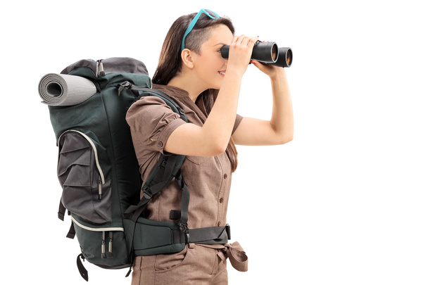Female hiker looking through binoculars - Фото, зображення