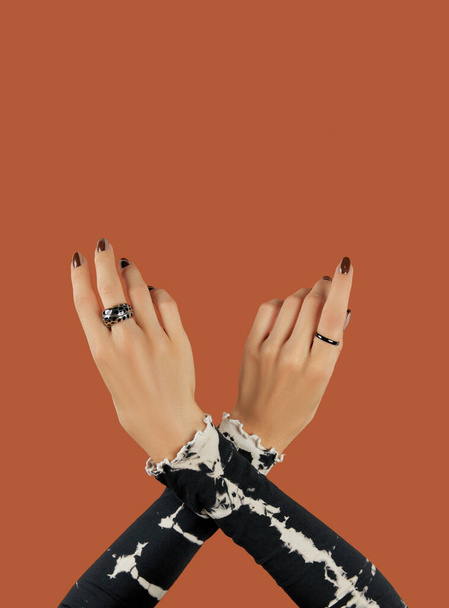 Γυναικεία χέρια με μοντέρνο καφέ μανικιούρ. Φθινοπωρινή σχεδίαση νυχιών - Φωτογραφία, εικόνα
