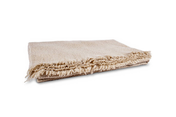 Бежевое шерстяное сложенное одеяло на белом фоне - Фото, изображение