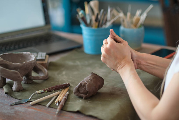 ambachtelijke aardewerk leraar in kunststudio. vrouw keramist geeft een online les of leidt een video master class over het maken van keramische producten - Foto, afbeelding