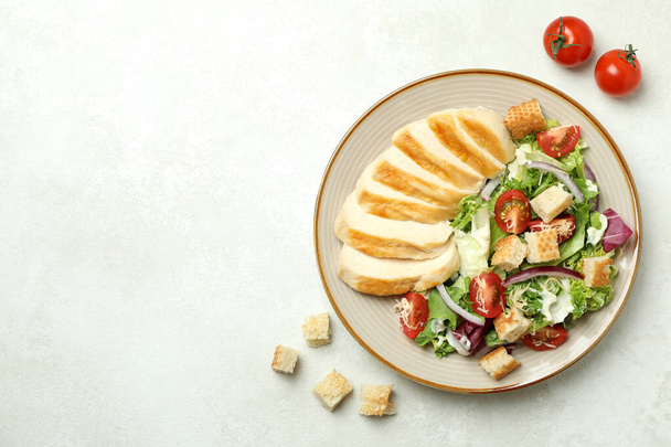 Plate with Caesar salad and ingredients on white textured background - Foto, immagini