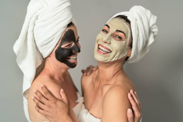 Happy middle age women with facial mask having skin care spa day - People selfcare lifestyle concept - Foto, imagen
