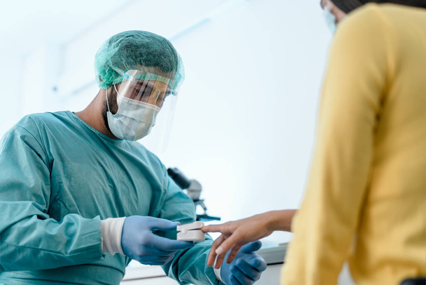 Medizinisches Personal untersucht Sauerstoffversorgung einer Patientin mit neuem Oximeter-Gerät während des Coronavirus-Ausbruchs - Foto, Bild
