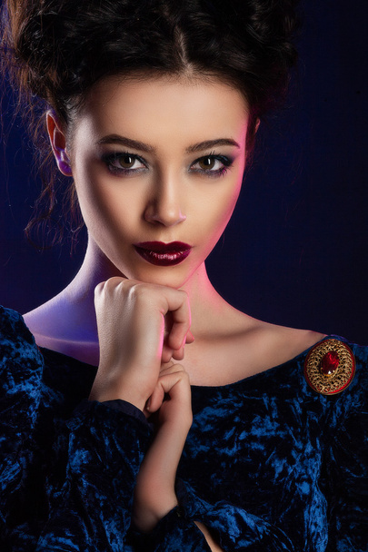 Fashion studio shot of beautiful woman with makeup and hairstyle wearing evening dress - Foto, imagen