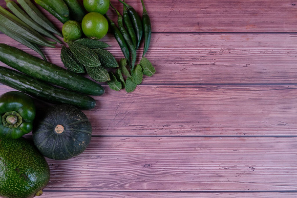 Las verduras verdes son buenas para el cuerpo. Verduras verdes se colocan sobre la mesa, vistas desde arriba. - Foto, imagen