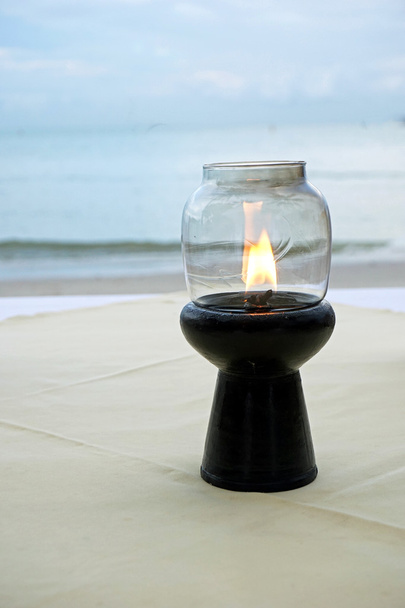 La vela enciende una mesa. Cena romántica junto al mar
 - Foto, imagen