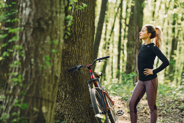 Woman riding a mountain bike in the forest - Фото, зображення