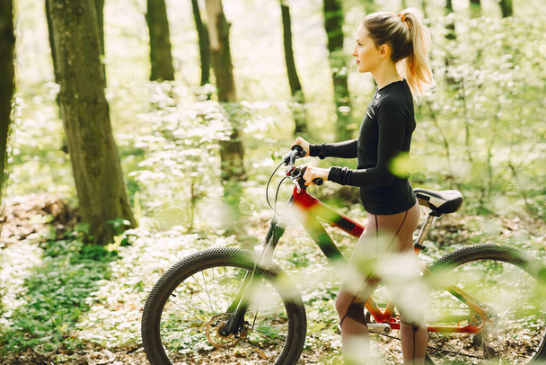 Woman riding a mountain bike in the forest - Foto, Imagem