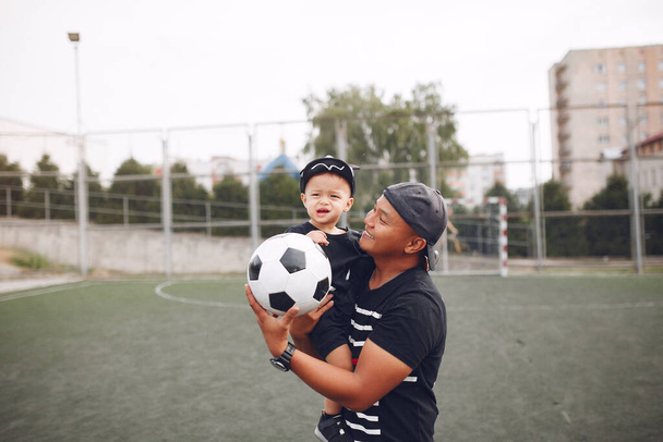 Father with little son playing a football - Фото, изображение
