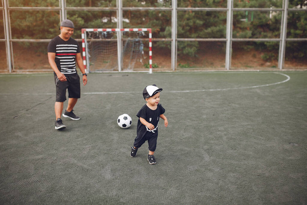 Father with little son playing a football - Φωτογραφία, εικόνα