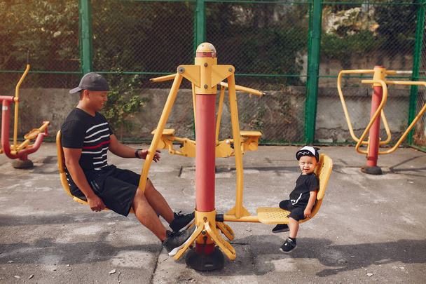 Family with little son playing on a playground - Foto, Imagem