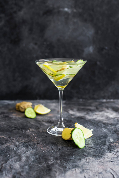 Summer cooling drink with fresh cucumber, lemon and ginger. Drink in a beautiful glass. summer drink on the dark background - Foto, Imagen