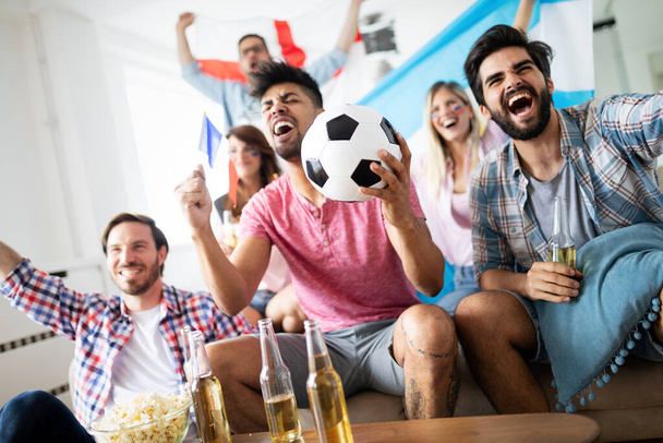 Excited and happy fans of soccer friends celebrating winning match at home - Foto, Imagen