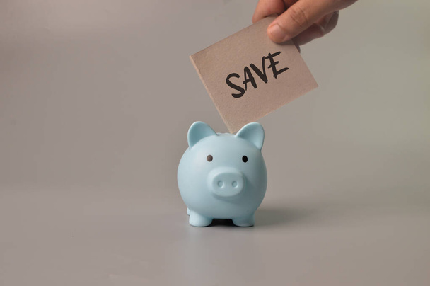 Man hand putting save note into piggy bank. Saving money concept. - Photo, Image