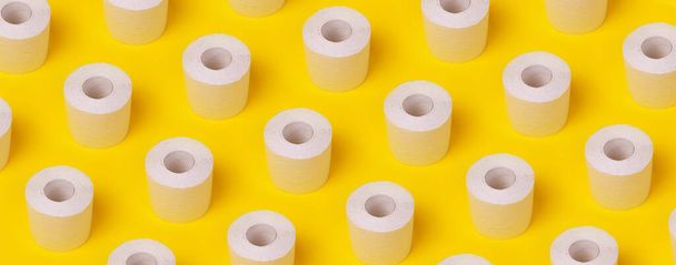 wzór z rolek białego papieru toaletowego na żółtym tle, obraz panoramiczny - Zdjęcie, obraz