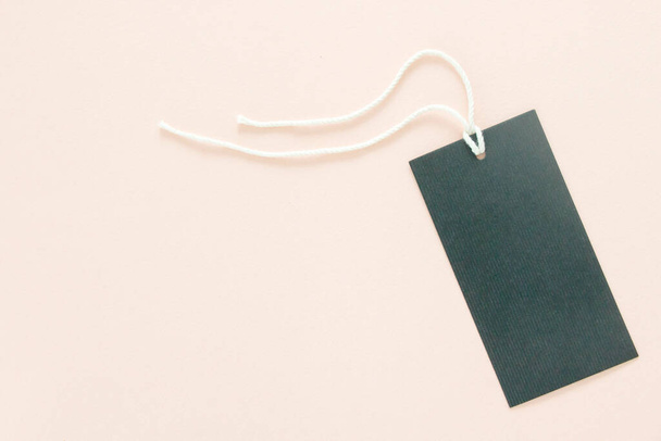 blanco papier tag met string op roze achtergrond - Foto, afbeelding