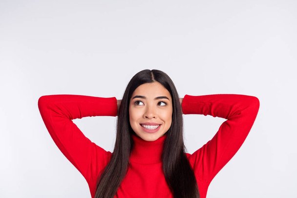 Photo of nice cheerful brown long hairdo lady look empty space hands head wear red sweater isolated on grey color background - Foto, afbeelding