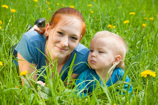 Mother and son laying on the green grass - Fotografie, Obrázek