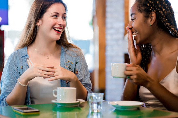 Two female friends enjoying a cup of coffee together. - Фото, зображення