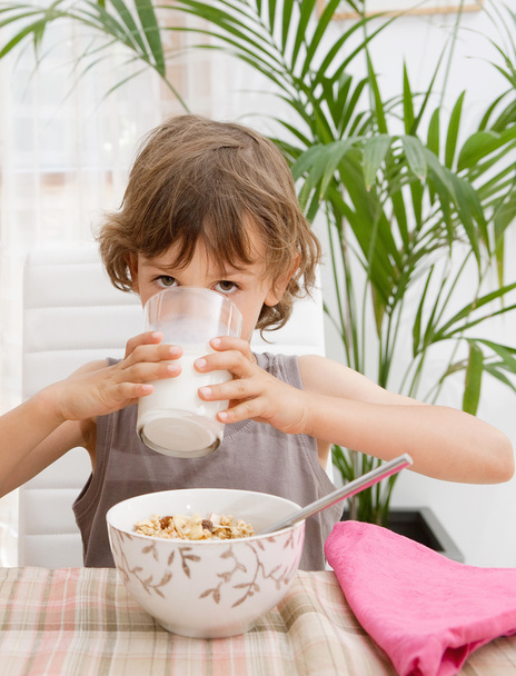 Niño sentado en casa junto a una mesa de desayuno
 - Foto, imagen