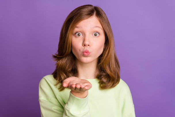 Photo of young attractive preteen girl pouted lips send air kiss you flirty feelings isolated over purple color background - Foto, afbeelding