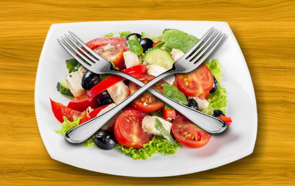Steel forks on top of a salad dish. Healthy food concept - Photo, Image
