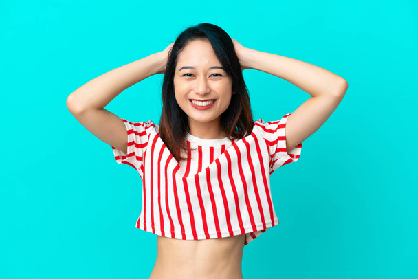 Young Vietnamese woman isolated on blue background laughing - Φωτογραφία, εικόνα