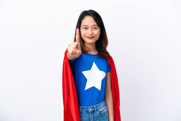 Jeune femme vietnamienne isolée sur fond blanc en costume de super-héros et pointant vers l'avant - Photo, image