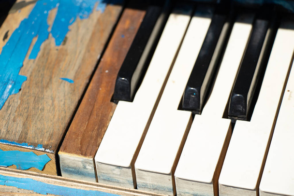 piano viejo con teclas en blanco y negro en la calle como fondo, concepto de música - Foto, imagen