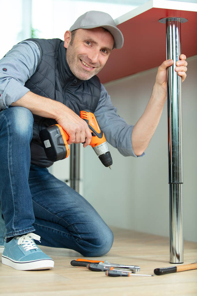 man installing a metal support for a breakfast-bar - Photo, image