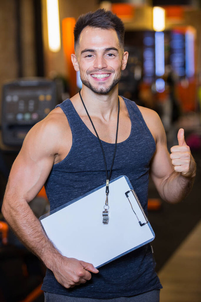 young man showing thumb up at gym - Foto, Imagem