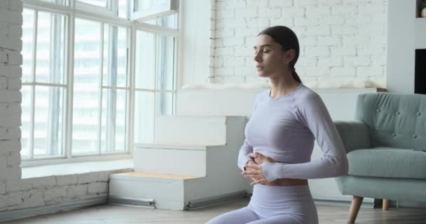 Młoda szczęśliwa kobieta ćwiczy jogę i wykonuje ćwiczenia oddechowe oglądając na żywo zajęcia z uczenia się wideo na tablecie. - Materiał filmowy, wideo