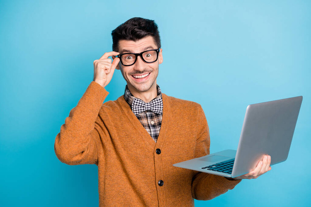 Photo of cheerful attractive young man hold hand laptop glasses amazed isolated on blue color background - Φωτογραφία, εικόνα