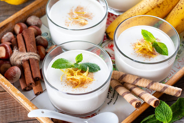 新鮮なバナナヨーグルト、ガラスのオート麦、健康的な朝食のためのおいしいデザート - 写真・画像