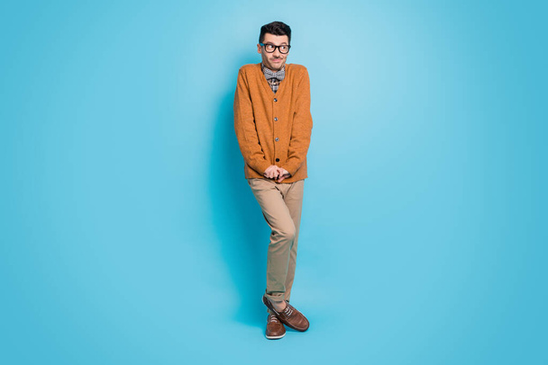 Full size photo of shy modest young nerd guy make timid pose hold hands together isolated on blue color background - Foto, Imagen