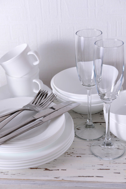 Set of white dishes on table on light background - Fotoğraf, Görsel